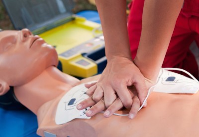 Practicing defibrillator CPR procedure on a dummy